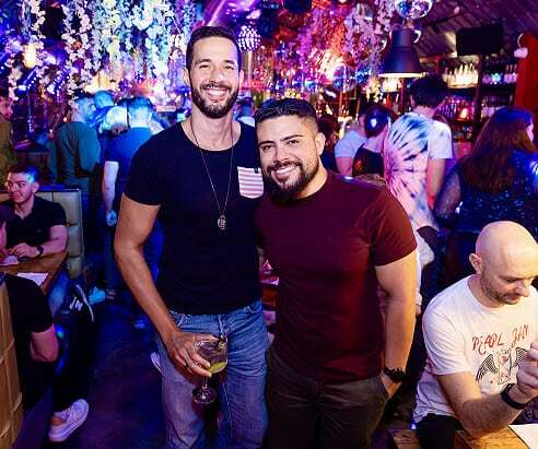 A happy couple celebrating a special event at Arch Clapham, possibly the best gay bar in London.