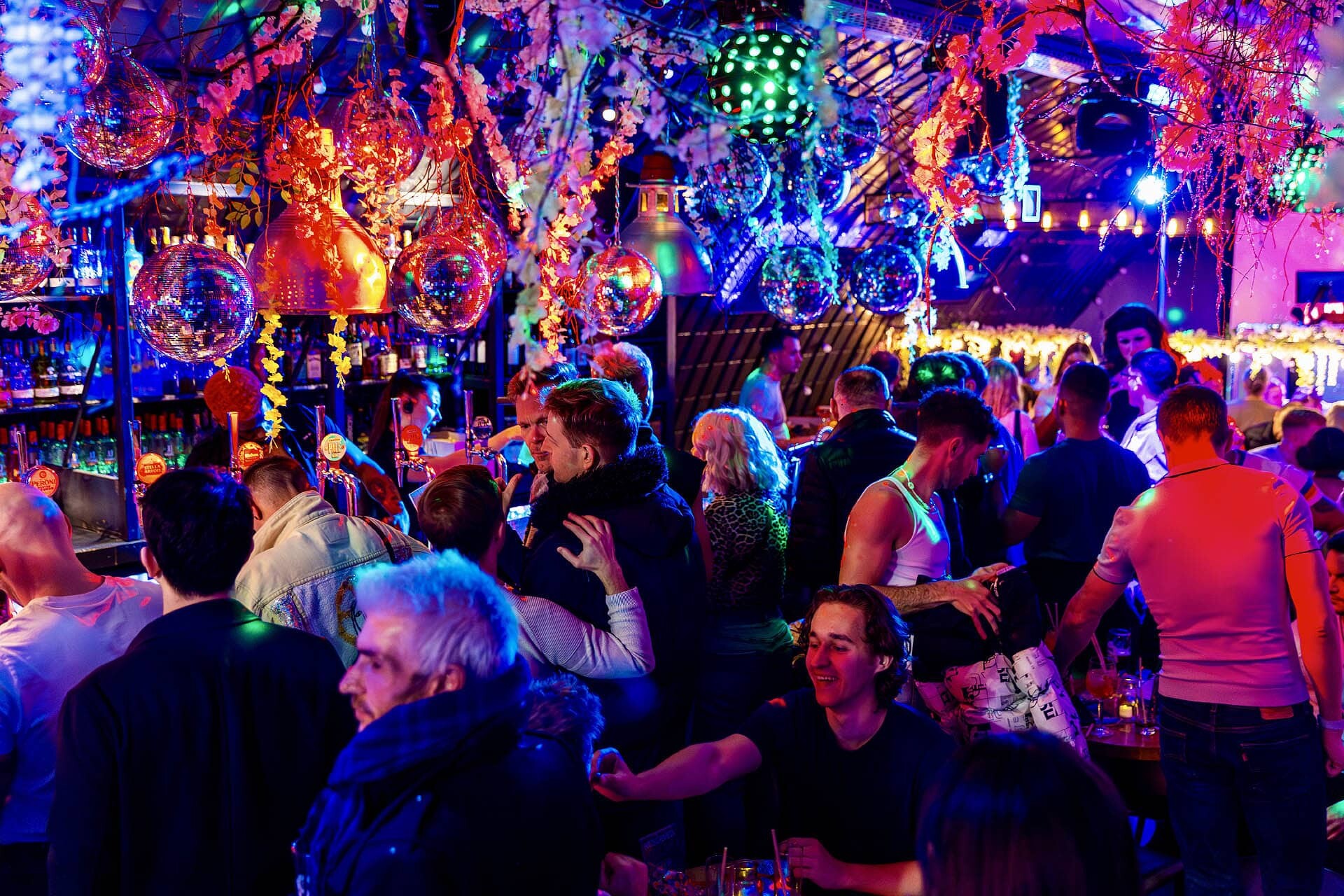A lively crowd celebrates a special event at Arch Clapham, possibly the best gay bar in London.