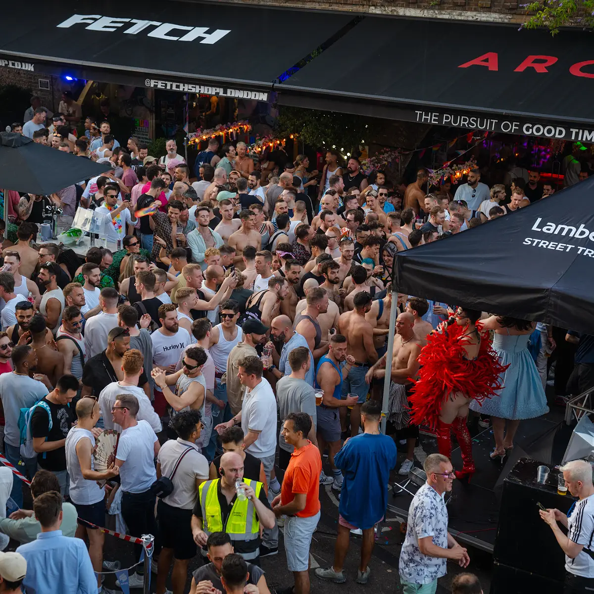Crowds celebrating Clapham Pride at Arch Clapham street party with drag performers, DJs, dancing and a lively LGBTQ+ atmosphere on Voltaire Road.